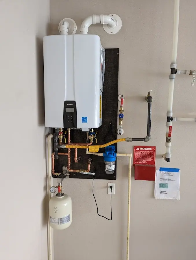 Professional plumber installing copper piping in a Mooers home